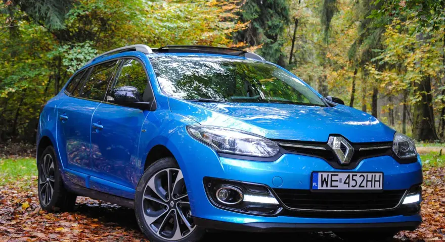 Niebieski Renault Megane 2 1.6 16v na tle jesiennego lasu.
