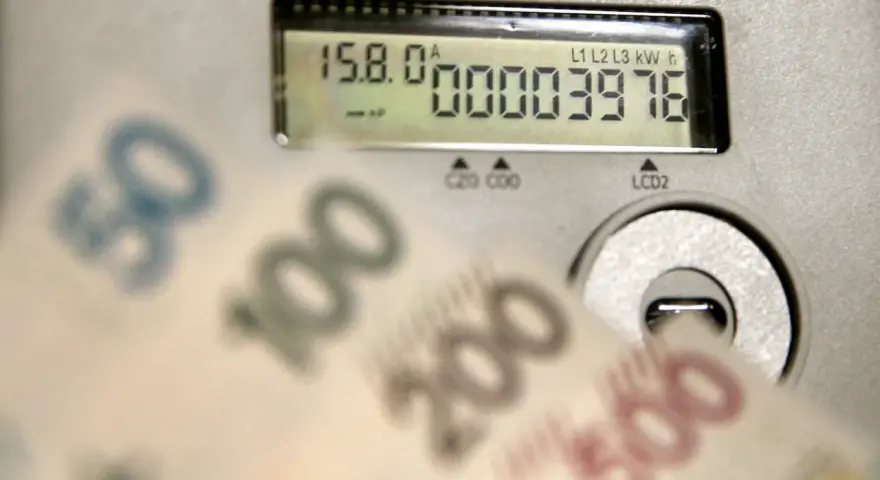Opłata kogeneracyjna co to? Licznik energii i banknoty 50, 100, 200, 500 zł sugerują wysokie rachunki za prąd.