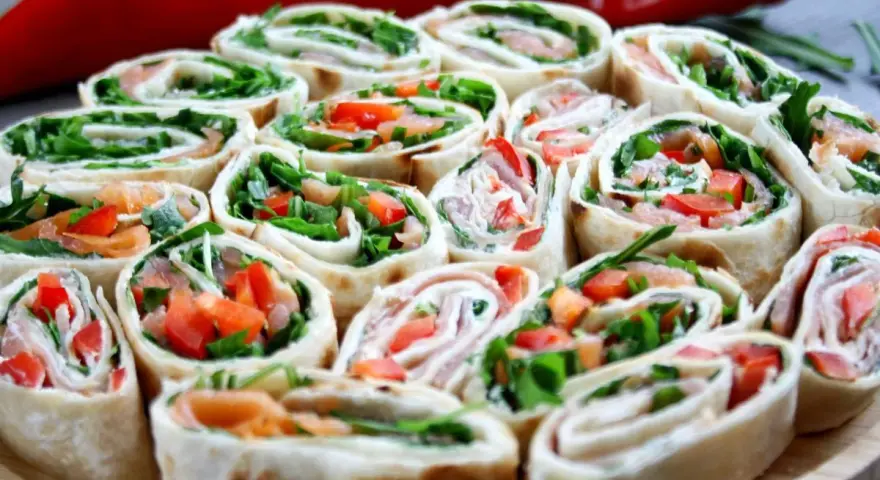 Szybkie przekąski z tortilli na zimno: rolki z łososiem, rukolą i papryką. Idealne na imprezę lub jako lekki lunch.
