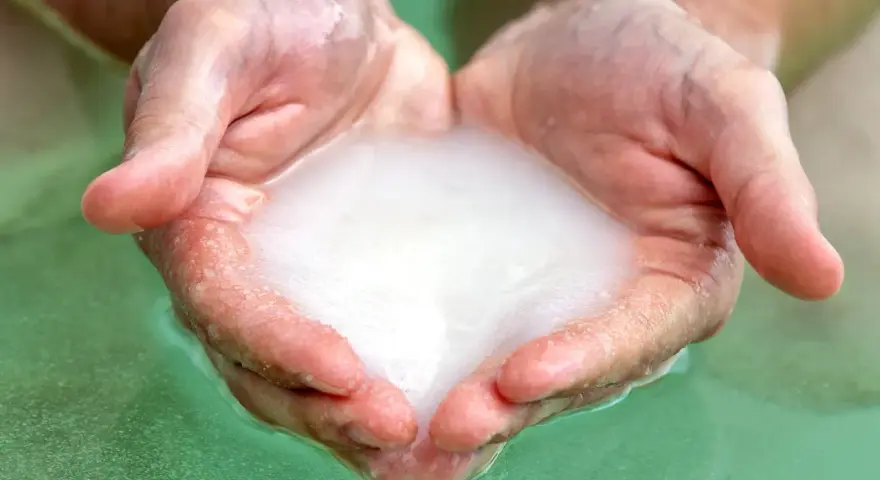 Hands cupped, holding foamy water, ready for a relaxing magnesium foot soak.