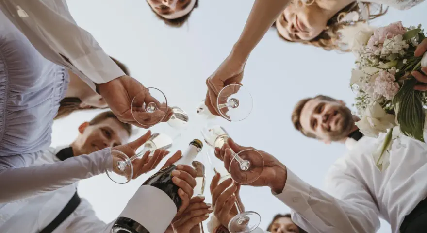 Różnica między poprawinami a wspólnym śniadaniem dla gości: toast szampanem z bliskimi, uśmiechy i bukiet panny młodej.