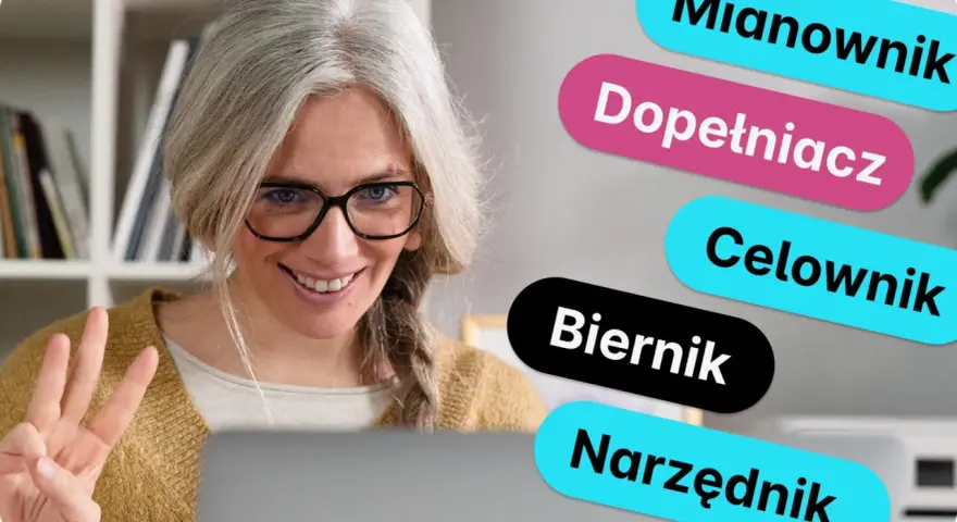 Kobieta z siwymi włosami i okularami uśmiecha się, pokazując trzy palce. Obok niej kolorowe napisy: Mianownik, Dopełniacz, Celownik, Biernik, Narzędnik – to rzeczownik od czasownika.