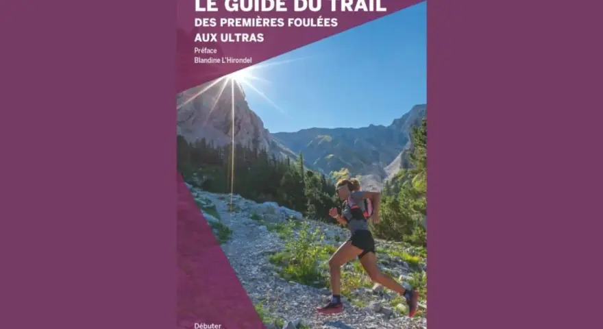 Couverture du livre "Le Guide du Trail", montrant une femme en pleine rando course en montagne sous un soleil éclatant.