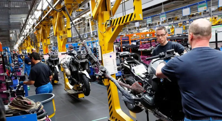 Männer arbeiten an Motorrädern in einer Fabrik. An Christi Himmelfahrt muss man anscheinend arbeiten.