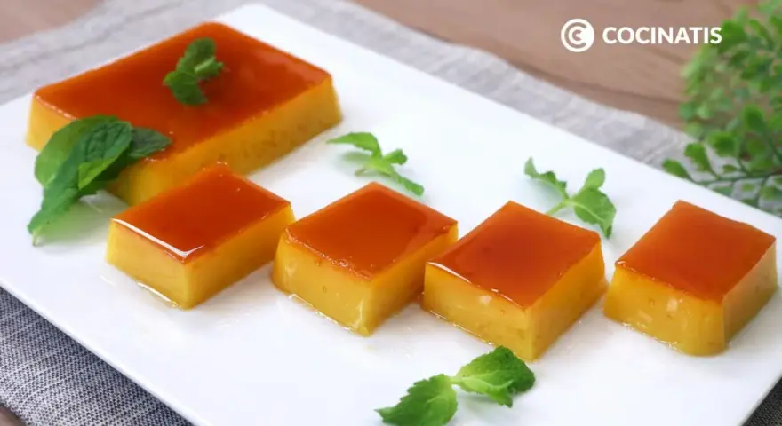 Delicioso tocino de cielo en porciones, decorado con hojas de menta fresca sobre un plato blanco.