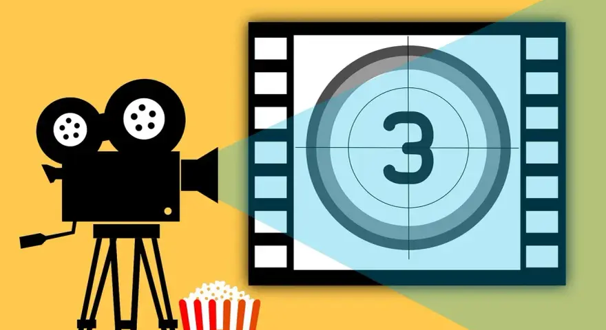 Kamera filmowa, popcorn i plansza z cyfrą 3 – idealne na wieczór z filmami o fotografii.