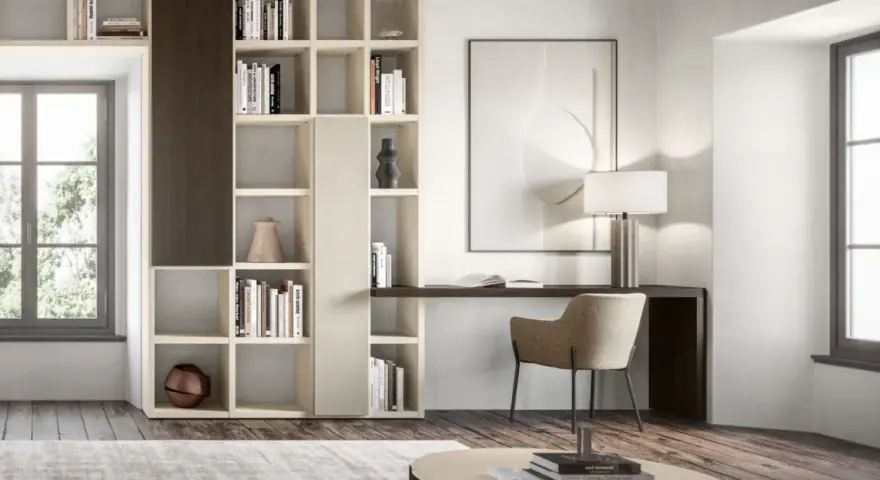 Un piccolo angolo studio in salotto, con libreria componibile, scrivania, sedia e lampada.