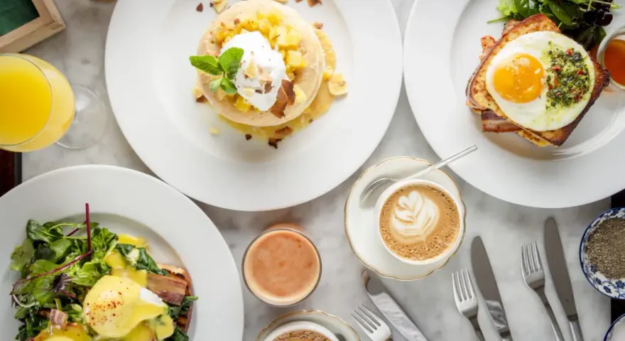 Ein köstlicher Brunch in Berlin: Pancakes mit Früchten, Eggs Benedict und Croque Madame mit Spiegelei. Dazu Kaffee und Saft.