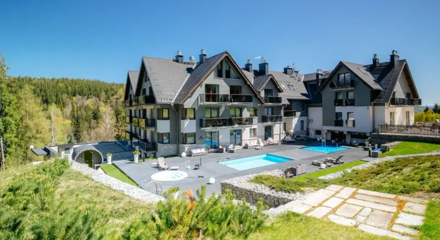 Nowoczesny hotel w Szklarskiej Porębie z basenem i jacuzzi, otoczony zielenią i lasem. Idealne miejsce na wypoczynek.