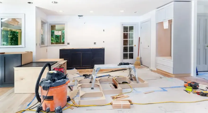Chantier d'un appartement en rénovation : armoires sombres, structure en bois, aspirateur, outils. Idéal pour des conseils rénovation appartement.