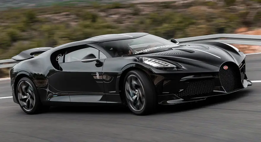 Czarny Bugatti La Voiture Noire pędzi po krętej drodze. Zastanawiasz się, ile kosztuje ten cud motoryzacji?