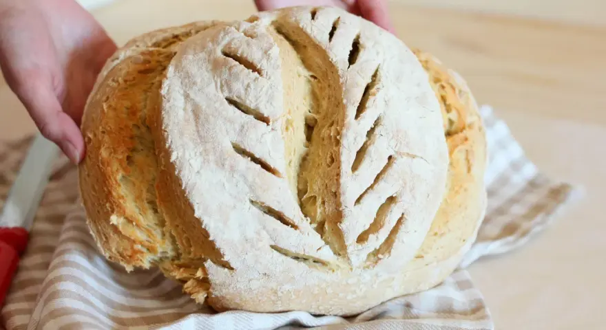 Pane fatto in casa, fragrante e dorato, con tagli che ricordano la ricetta della nonna.