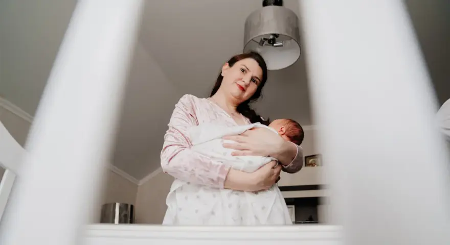 Matka tuli dziecko, które lekko się wierciło, jakby czuło stan podgorączkowy u niemowlaka.