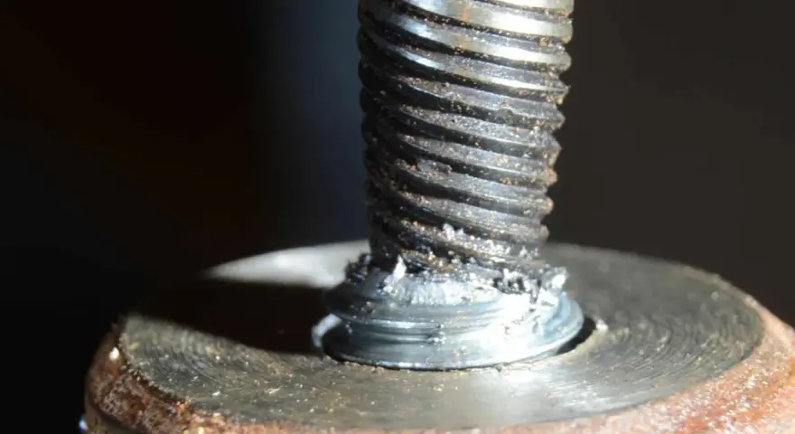 Uszkodzona śruba w aluminiowej obudowie. Widoczne ślady po próbie wykręcenia urwanej śruby z aluminium.