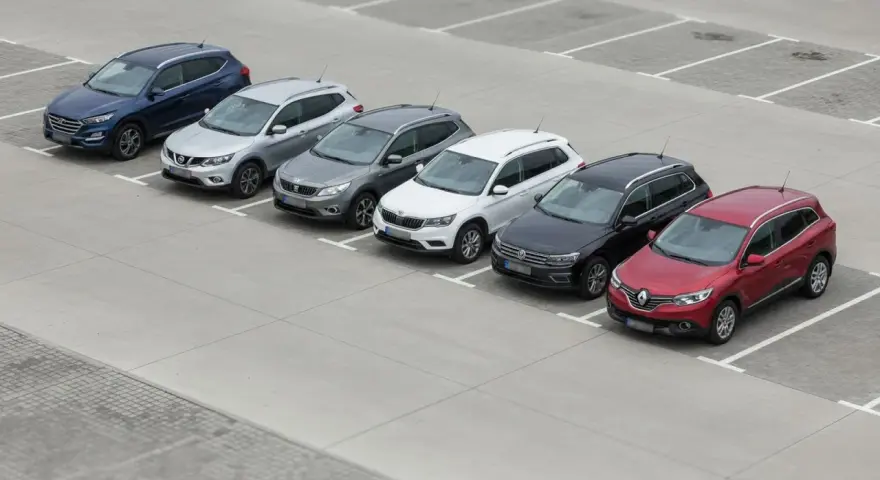 Rząd siedmiu SUV-ów zaparkowanych na placu.