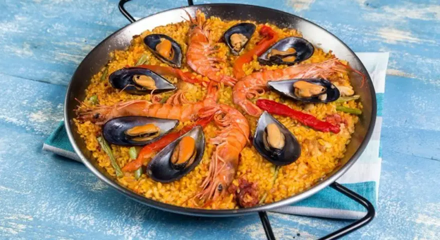 Paella mixta con gambas y mejillones, un festín de sabores mediterráneos en una paellera.