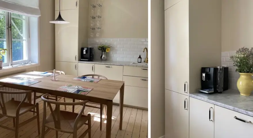 Ljust kök med träbord och stolar. Nya köksluckor ger ett fräscht intryck. Kaffemaskin och blommor på bänken.