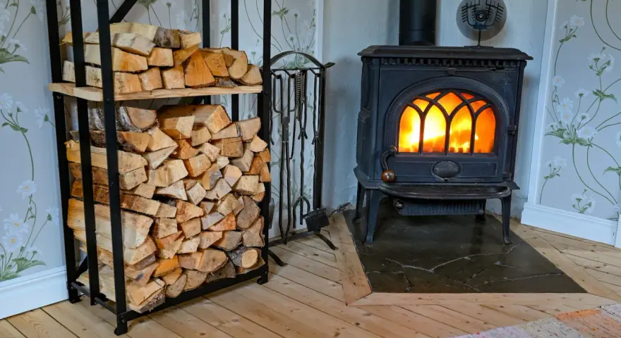En kamin med glödande eld och en vedstapel redo för att installera kamin.