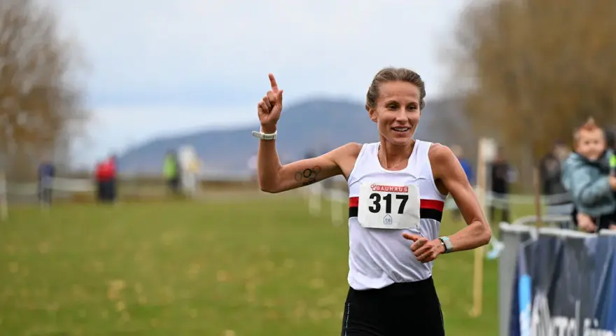 Sarah Lahti firar en seger, nummer 317, med ett leende och en uppsträckt arm.