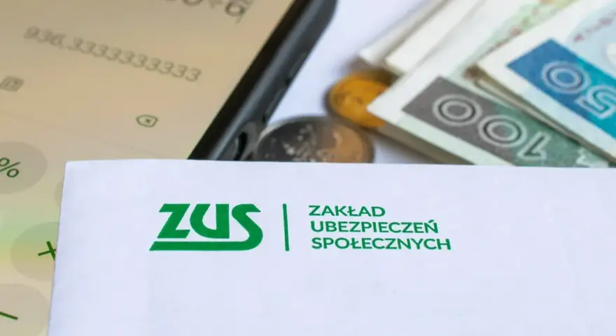 ZUS, pieniądze, monety i kalkulator na ekranie telefonu.