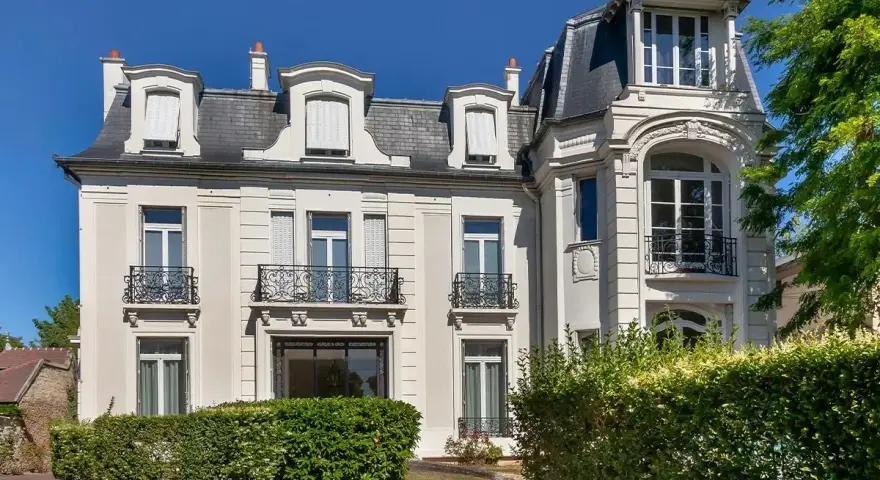Belle demeure avec balcons en fer forgé, idéale pour une vente à réméré. Le soleil brille sur cette propriété.