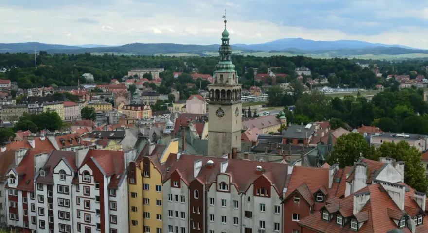 Widok na kłodzko stare miasto z charakterystyczną wieżą zegarową i kolorowymi kamienicami.