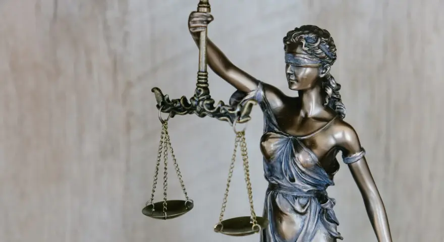 Figurka Temidy z wagą symbolizuje sprawiedliwość, która jest kluczowa przy nowelizacji kodeksu karnego.