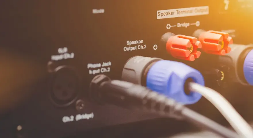 Złącza Speakon i zaciski głośnikowe na wzmacniaczu, pokazujące różne **cable types** do podłączenia sprzętu audio.