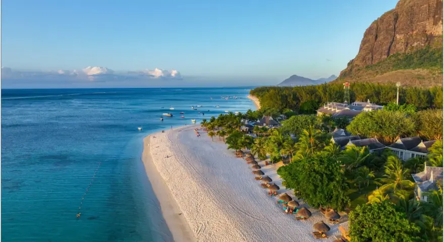 Rajska plaża na Mauritiusie, idealna temperatura do opalania. Woda kusi turkusowym blaskiem, a palmy szumią na wietrze.