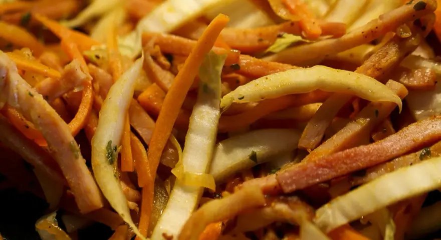 Pokrojone w słupki marchewka, fasolka i inne warzywa w daniu stir-fry.