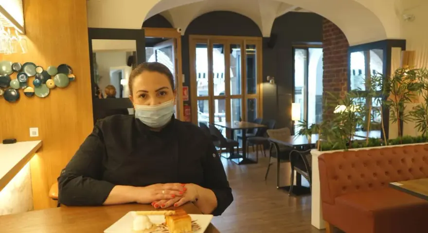 Chef con mascarilla en un restaurante moderno, ideal para saber donde comer en Zafra. Postre en primer plano.