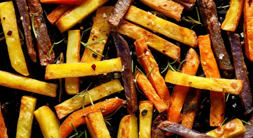 Pieczone frytki z ziemniaków i marchewki z rozmarynem i przyprawami.
