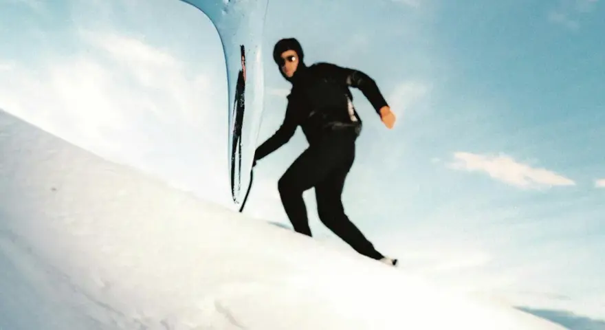 Kilian Jornet desciende el Mont Blanc con agilidad, su silueta negra contra la nieve y el cielo azul.