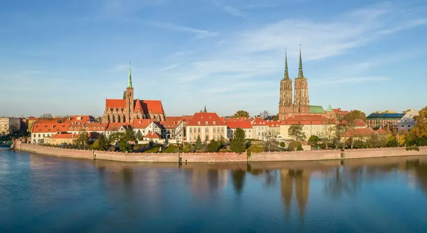 Wrocław stare miasto z katedrami i Ostrów Tumski nad Odrą, odbijające się w spokojnej wodzie.