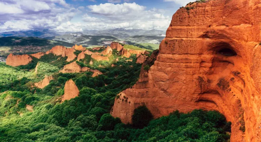 Paisaje dramático de Las Médulas, uno de los parques de España más impresionantes, con sus rocas rojizas y vegetación exuberante.