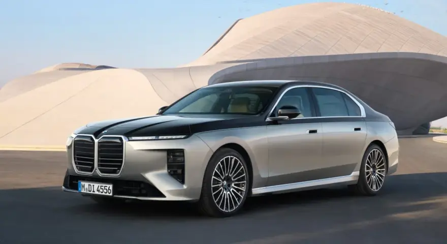 Elegancki BMW 740d w dwukolorowym malowaniu, zaparkowany przed nowoczesnym budynkiem.