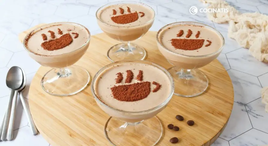 Cuatro copas de delicioso mousse de café, decoradas con cacao en polvo simulando una taza humeante.