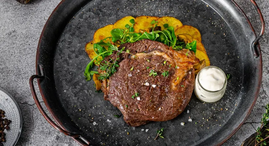 Un jugoso lomo bajo de vaca a la parrilla, acompañado de patatas crujientes y una salsa cremosa. ¡Un festín para los sentidos!