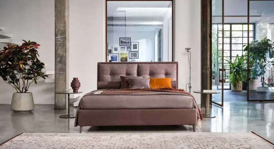 Elegante letto con testiera imbottita, parte di una collezione di **marchi camere da letto** di design.