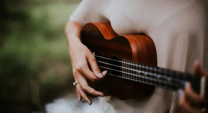 Dłoń grająca na ukulele, które jest często uważane za instrument, na którym najłatwiej nauczyć się grać.