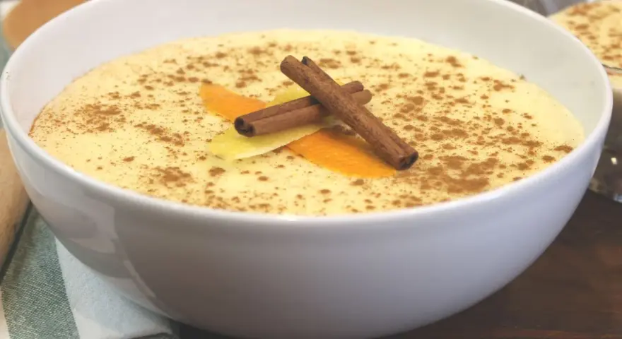 Delicioso arroz con leche thermomix, espolvoreado con canela y decorado con piel de naranja y limón.