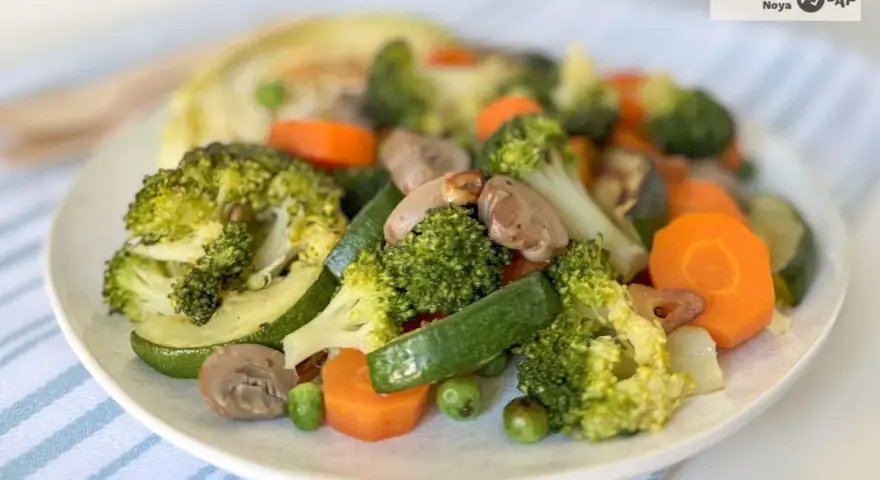 Un colorido panache de verduras salteadas: brócoli, zanahoria, calabacín, champiñones y guisantes.