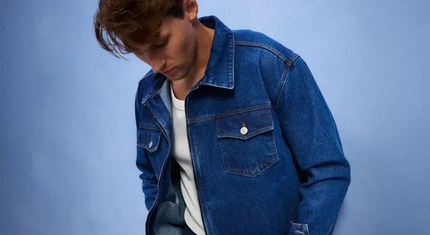 Mężczyzna w dżinsowej kurtce, idealnej do stworzenia uniwersalnej szafy kapsułowej. Klasyczny krój i niebieski denim.