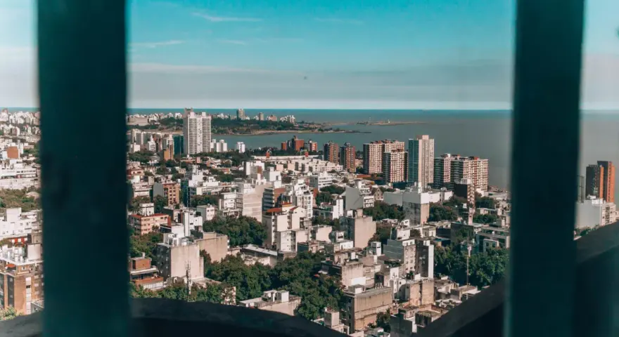 Widok na miasto z wieżowcami i zielenią, rozciągające się aż do morza. To stolica Urugwaju, Montevideo, tętniąca życiem metropolia nad Atlantykiem.