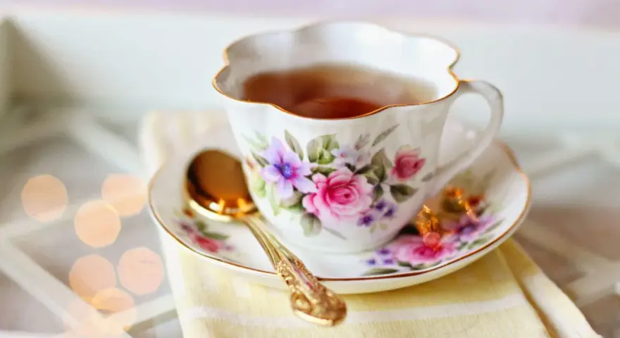 Elegancka filiżanka z kwiatowym wzorem, pełna aromatycznej herbaty. Czy herbata nawadnia? Ta z pewnością tak, dodając chwili relaksu.