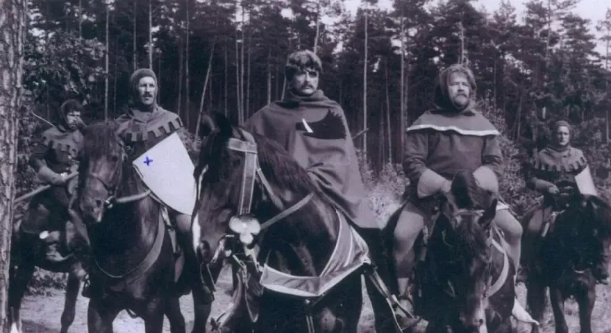 Scena z filmu, gdzie kręcono bitwę pod Grunwaldem. Rycerze na koniach w lesie, przygotowani do walki.