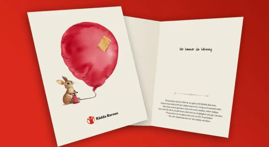 En kanin pumpar ett rött ballonghjärta med ett plåster. En barnvälsignelse present som stödjer Rädda Barnen.