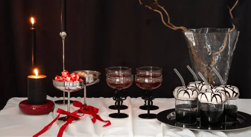 Ett festligt dukat bord med ljus, godis och drinkar. De svarta ljusstakarna med rosetter barn-tema ger en elegant touch.