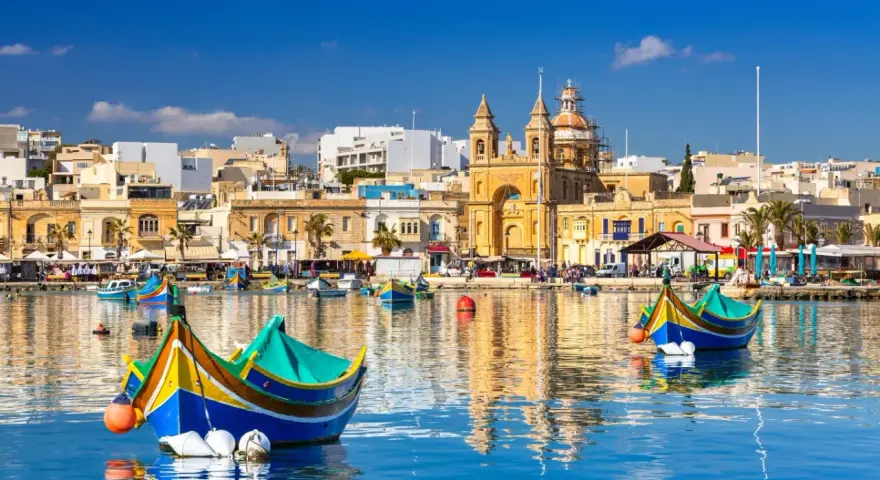 Malta: kolorowe łodzie luzzu w porcie, zabytkowa architektura i błękitne morze. Warto wiedzieć, że to malownicze widoki!