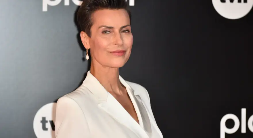 Danuta Stenka w białej kreacji, gwiazda filmów, seriali i programów, na tle logo TVN i Playera.